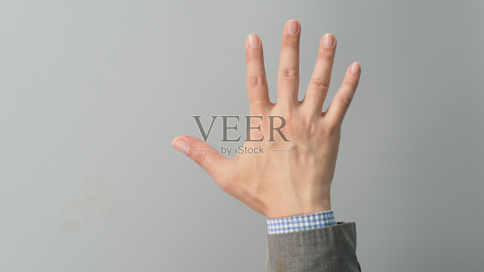 空手背和五指计数灰色西装颜色在灰色背景。商人的话题。特写照片和工作室拍摄。照片摄影图片