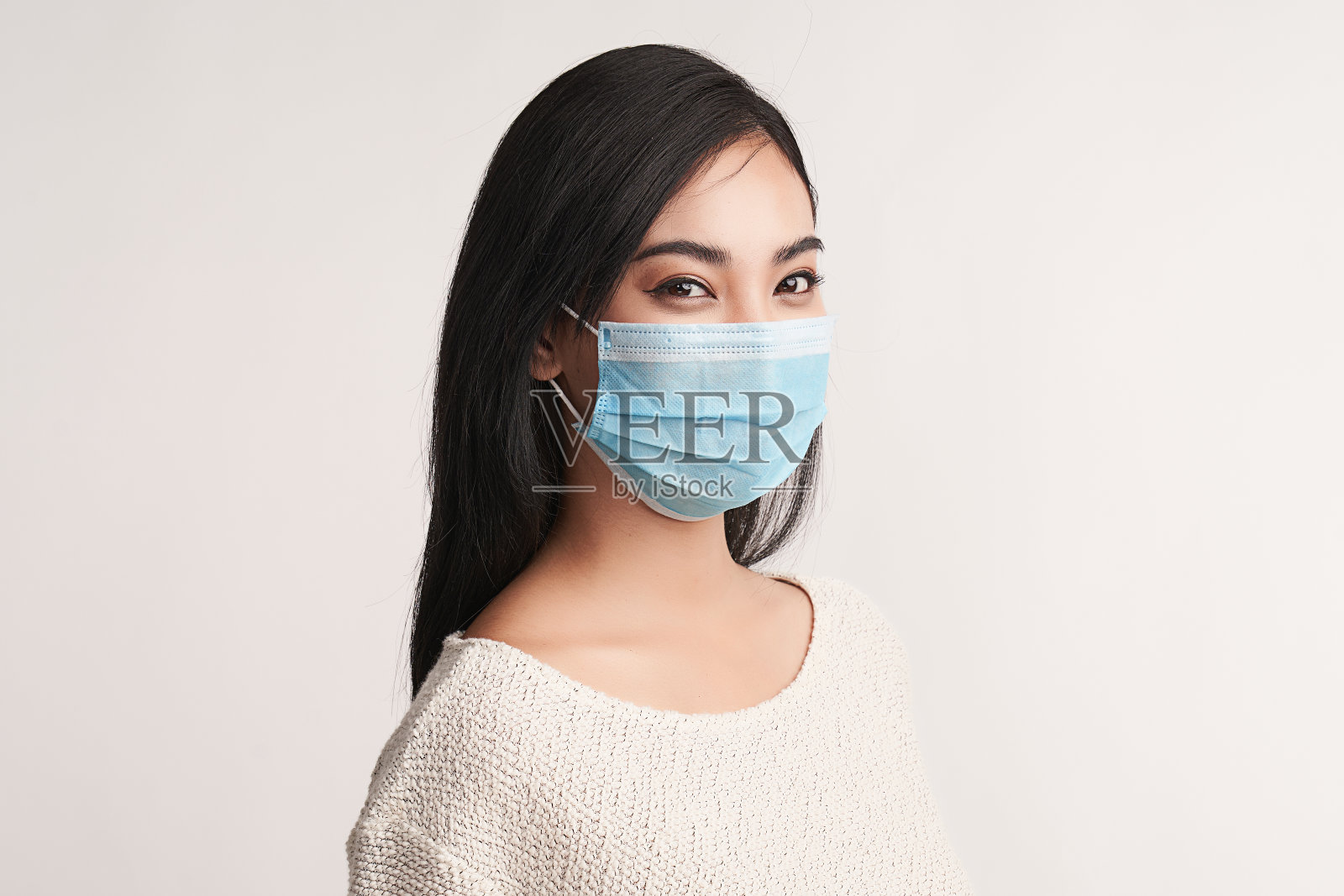 美丽的年轻亚洲女性在医疗面具在白色的背景，年轻女性病人，复制空间照片摄影图片