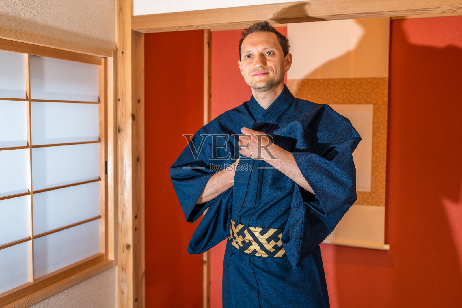 传统的日本町屋房间滑动门窗户和红色壁龛挂卷轴和快乐的人在蓝色和服微笑茶道仪式照片摄影图片