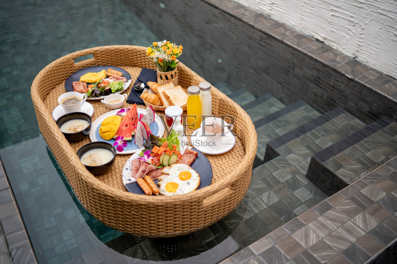 漂浮的早餐亚洲女孩在泳池边吃早餐。照片摄影图片