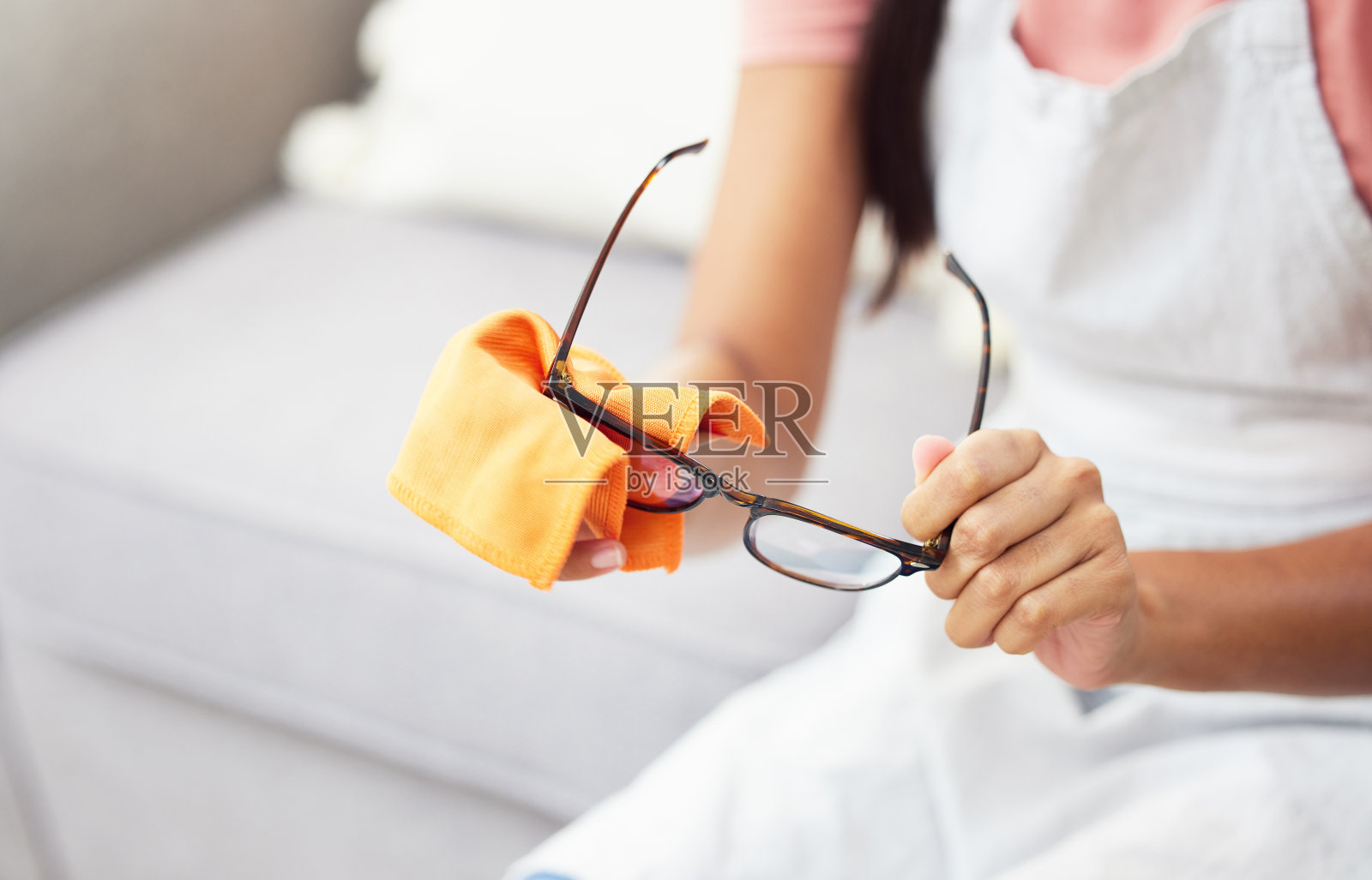 一个女人坐在家里擦眼镜的剪影照片摄影图片