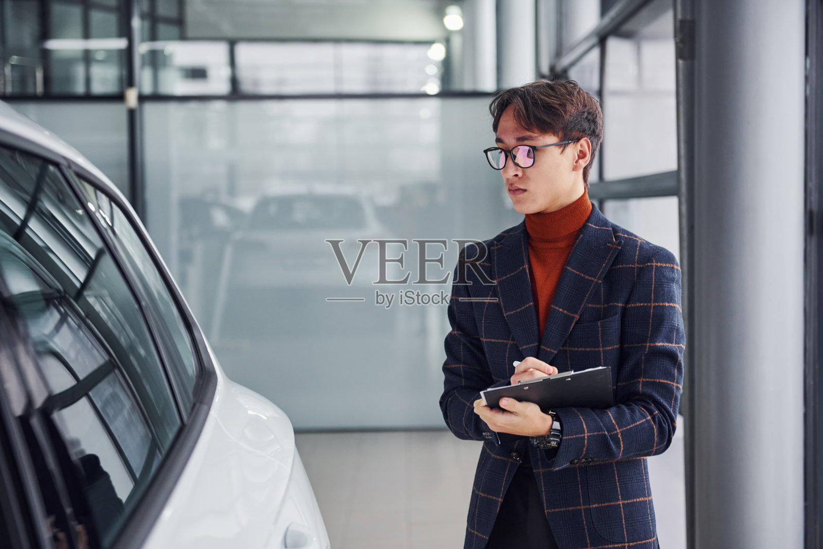 工人穿着正式的记事本看着现代汽车照片摄影图片