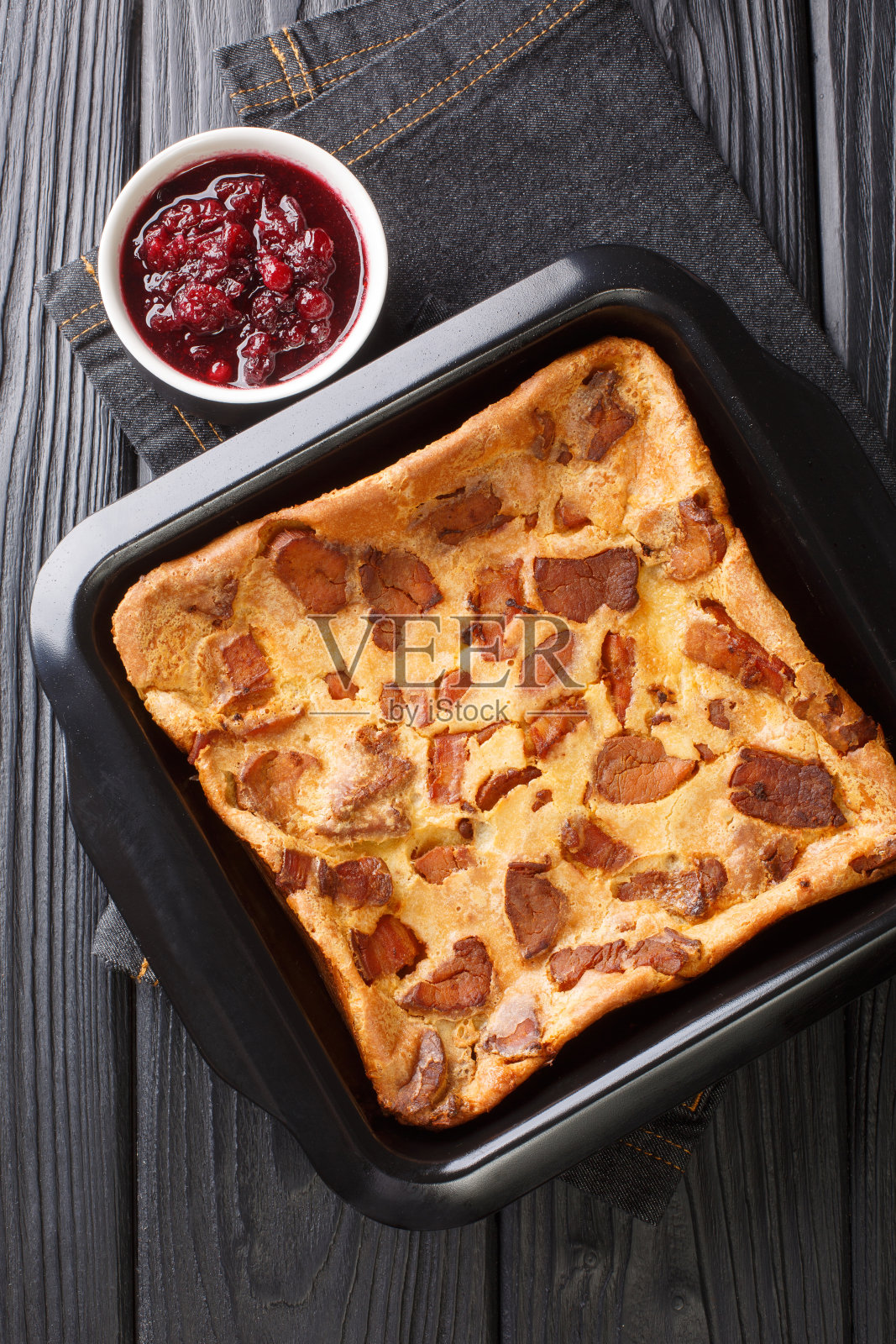 传统的新鲜烤瑞典肉煎饼与越橘酱在烤盘的特写。垂直的俯视图照片摄影图片