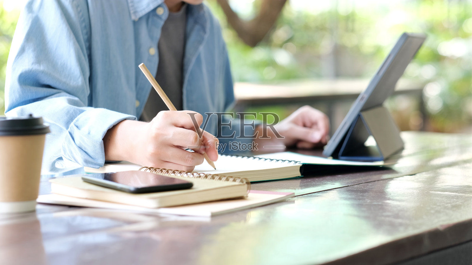 学习在线课程，学生在笔记本上手写，同时学习在线课程，教育和技术，在家工作照片摄影图片