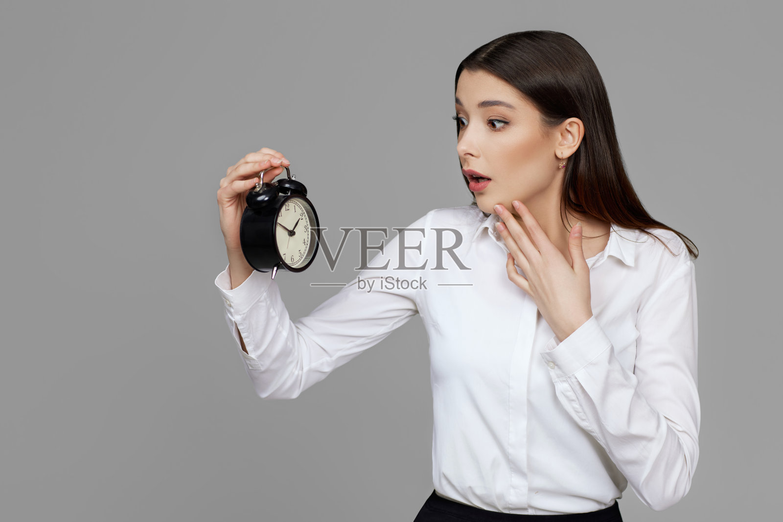 拿着闹钟的漂亮白种女商人照片摄影图片