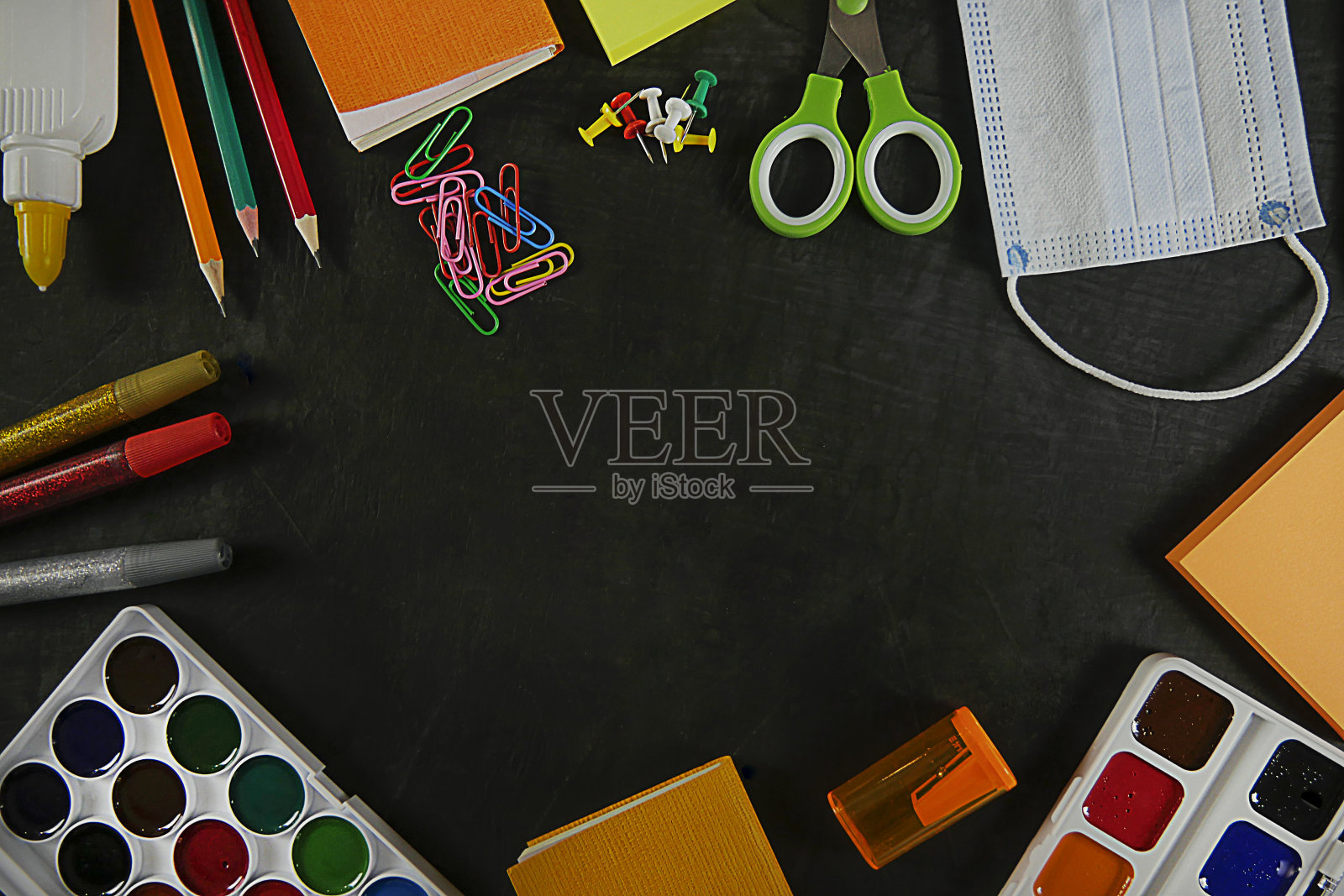 回到学校，接受教育。回到学校的黑板上。背景铅笔，颜料，面罩，回形针。从以上观点。本空间照片摄影图片