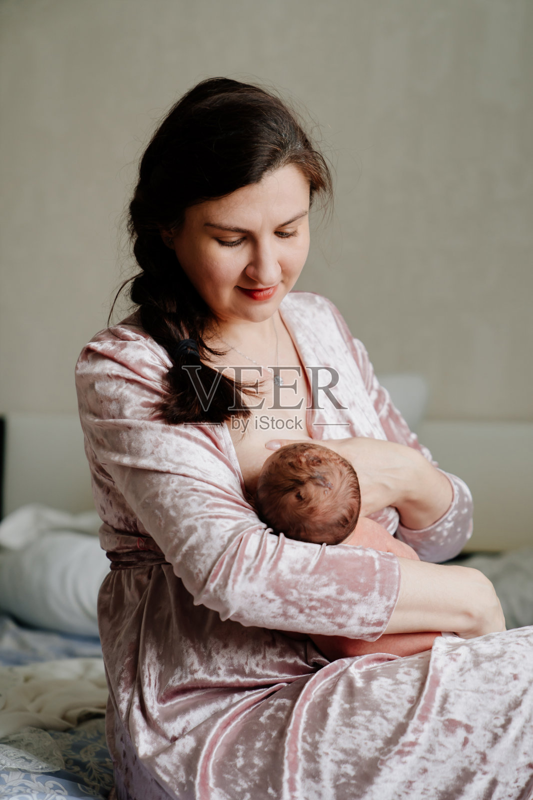 母亲用母乳喂养新生儿。母乳喂养的自然和方便。照片摄影图片