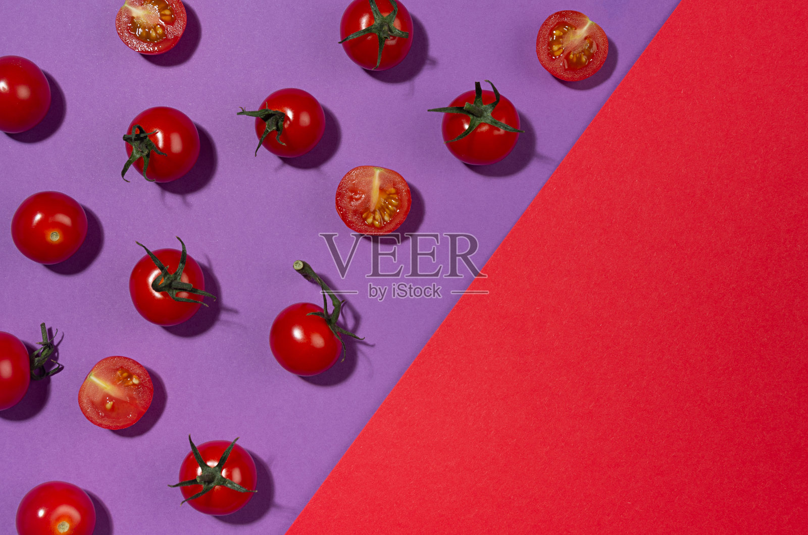 夏季颜色的食物背景-红色的樱桃番茄在阳光下与红色和紫色的背景阴影，平躺，边界，复制空间。照片摄影图片