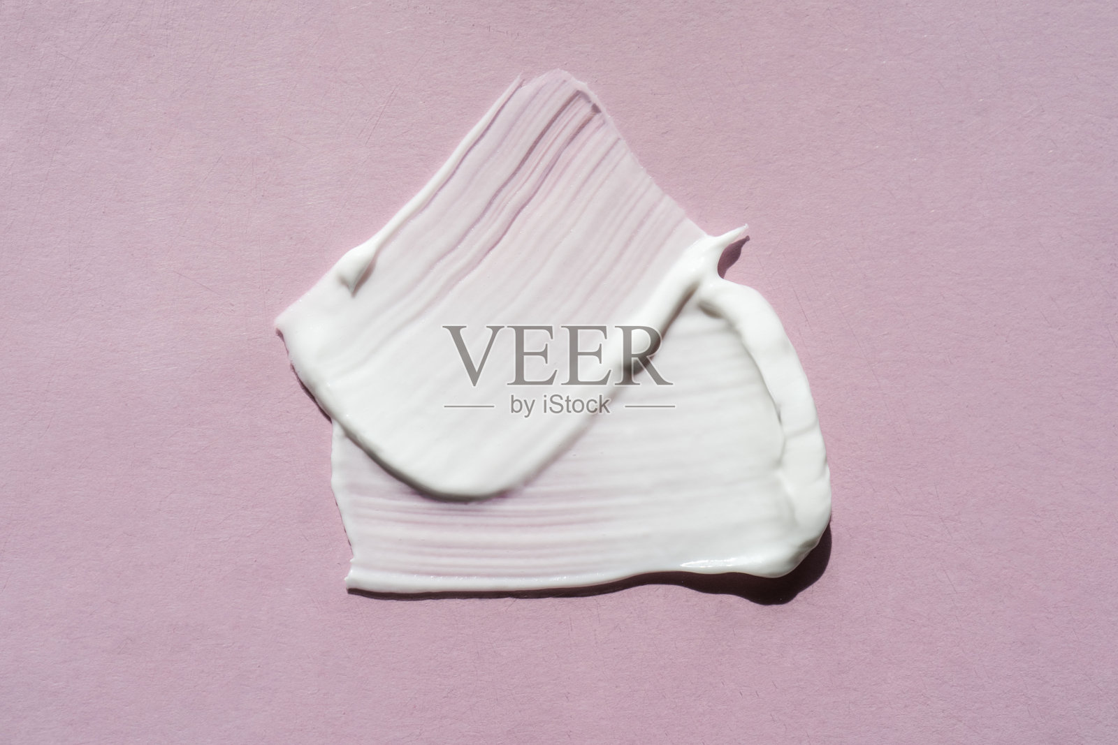 淡紫色背景上的白色奶油纹理。照片摄影图片