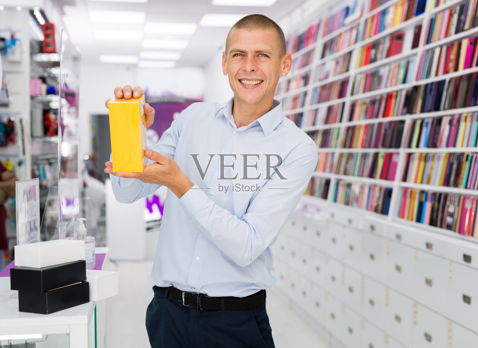 一个电子产品商店的售货员正在展示一个带有手机的盒子照片摄影图片