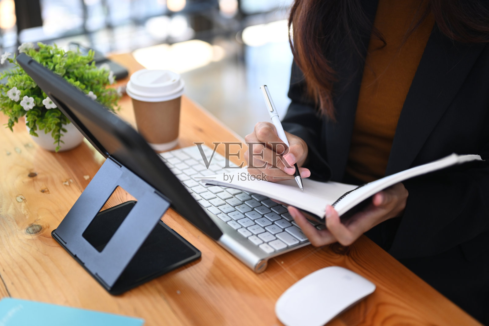 女商人使用平板电脑和在笔记本上做笔记的镜头。照片摄影图片