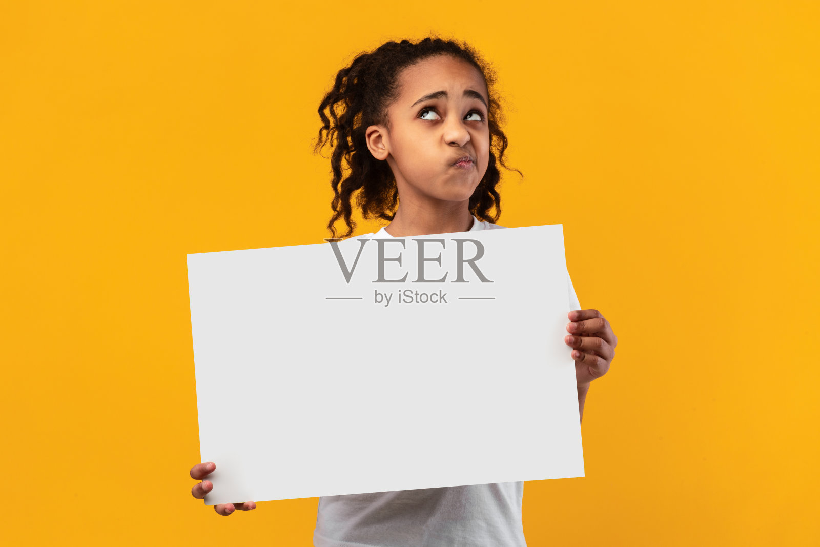 非裔美国女孩在演播室拿着空白的白色广告牌照片摄影图片