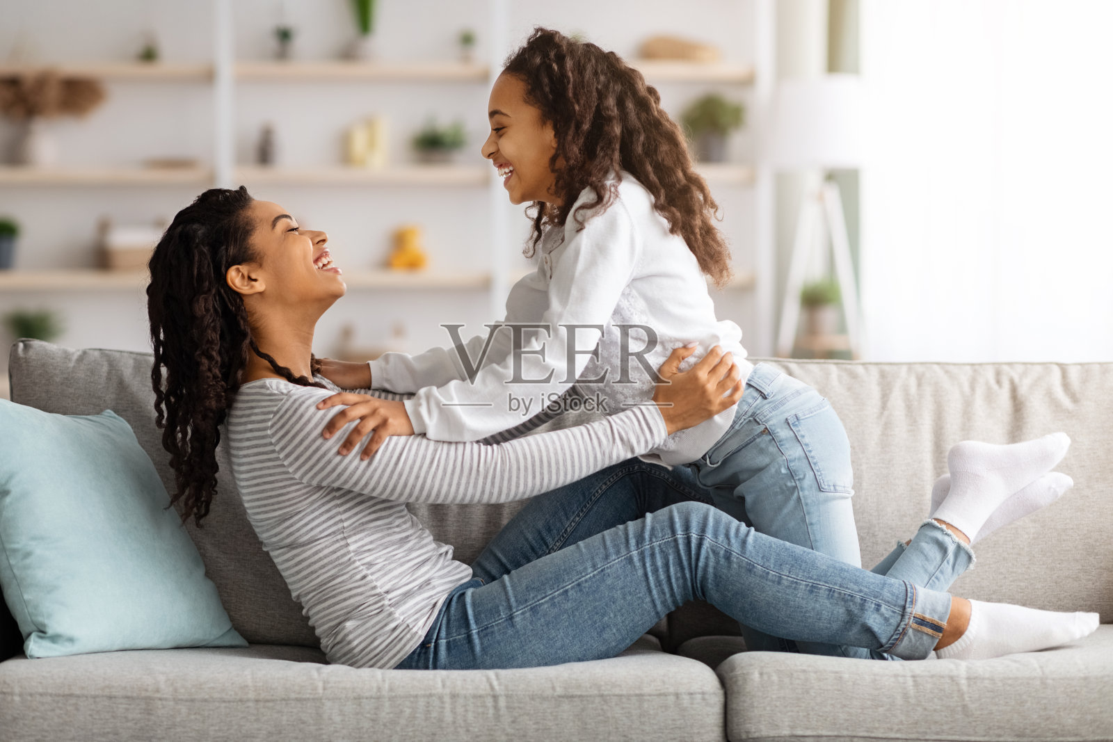 在沙发上放松的时候，有爱的黑人母亲和孩子建立了联系照片摄影图片