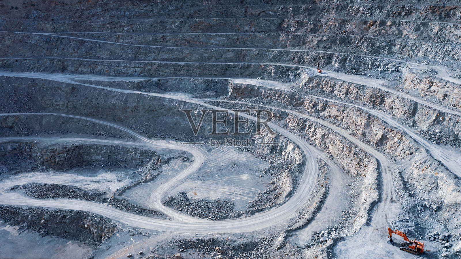 红色的挖掘机在采石场的平台上照片摄影图片