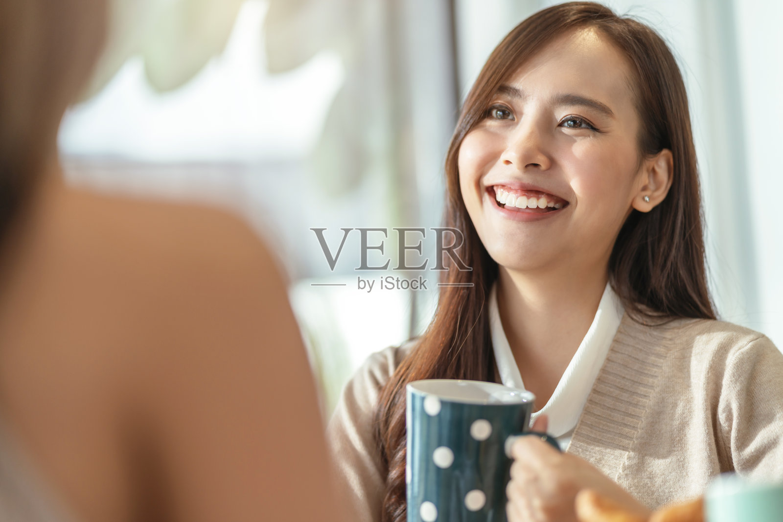 迷人的亚洲女性谈论良好积极的谈话与微笑的朋友和幸福的时刻在柜台靠近窗口的咖啡馆从花园日光积极的态度关系照片摄影图片