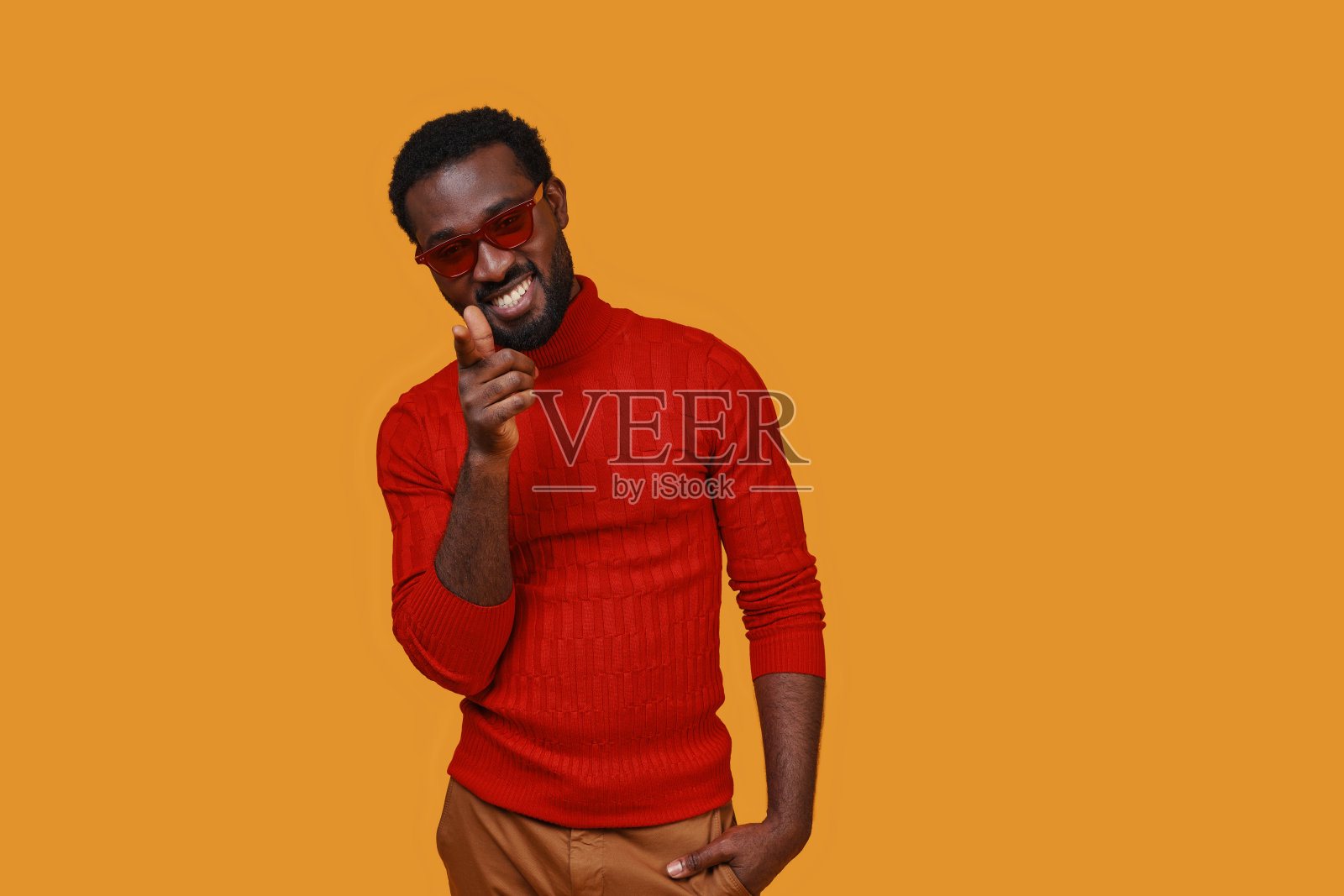 英俊的年轻非洲男子在休闲服装指向相机和微笑照片摄影图片