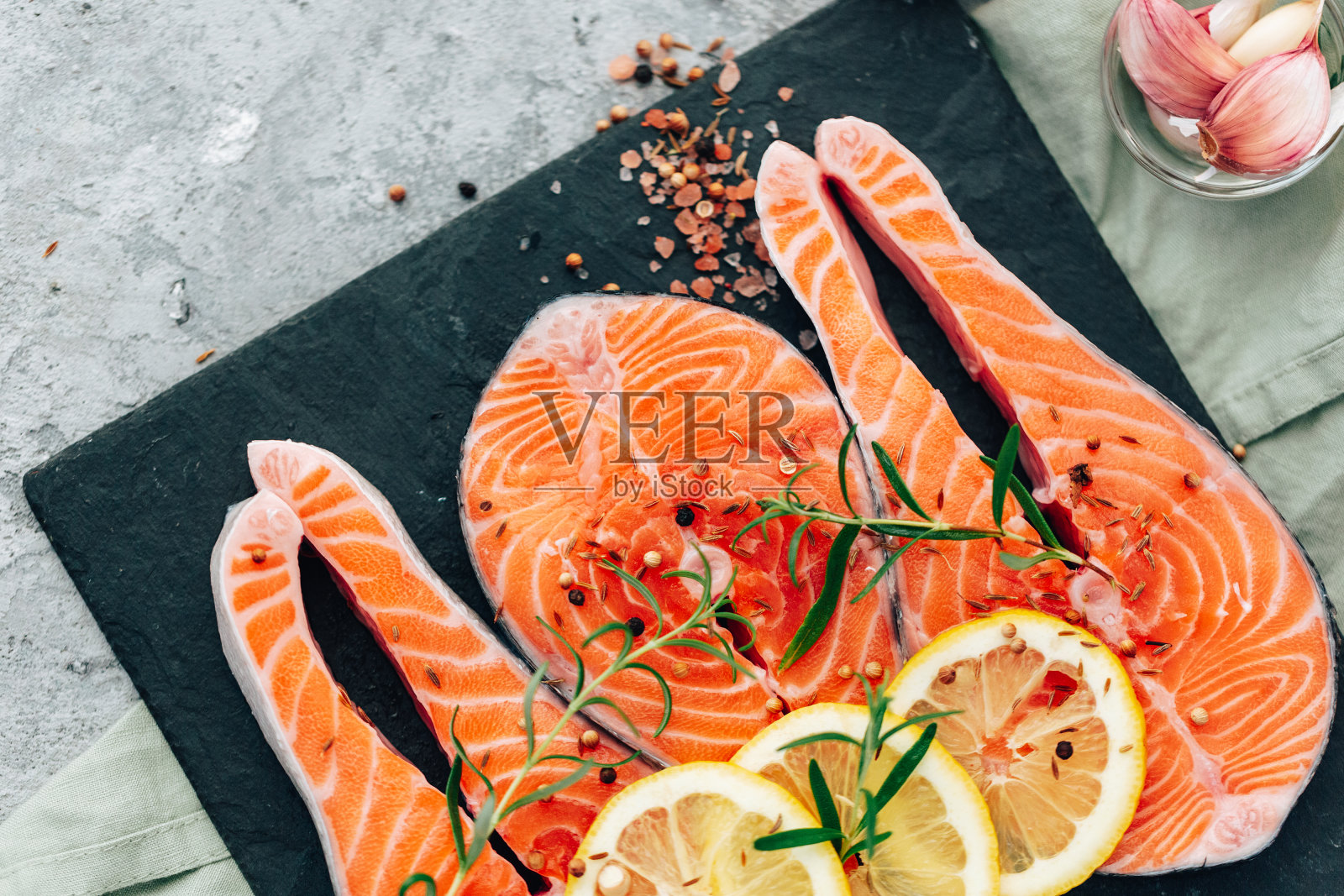 新鲜的三文鱼。鱼片配香草和柠檬。健康的食物，饮食或烹饪概念照片摄影图片