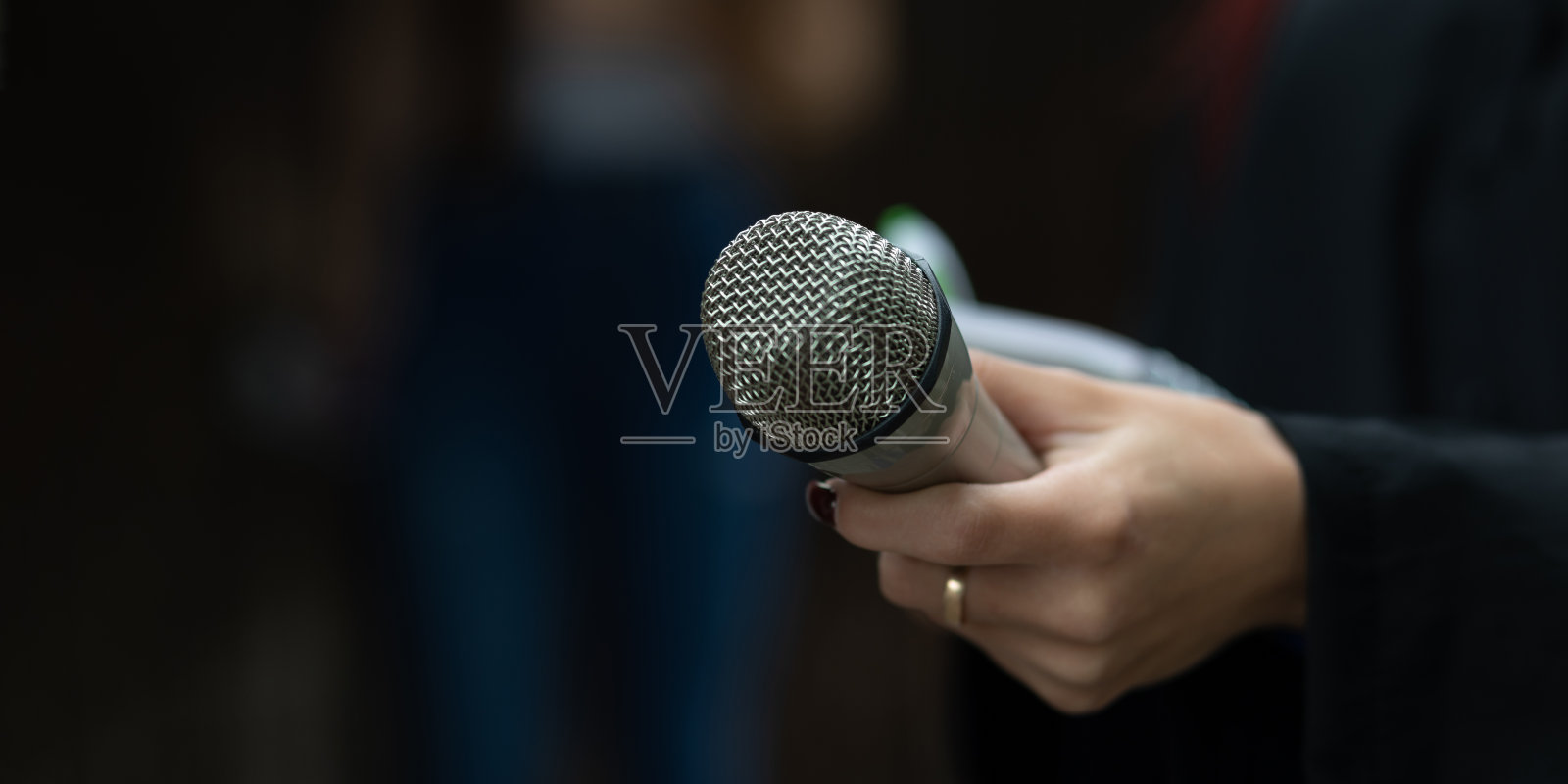 记者在新闻发布会上行动，写笔记，拿着麦克风照片摄影图片