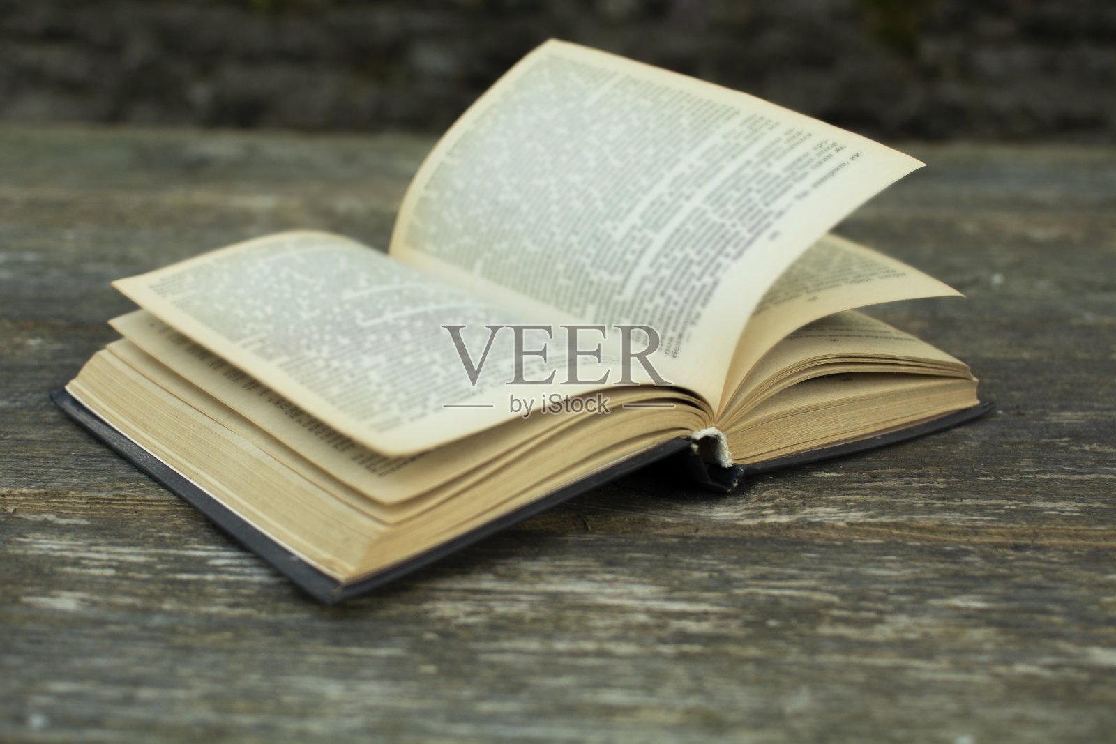 一本打开的旧书放在一张木桌上。教育理念照片摄影图片