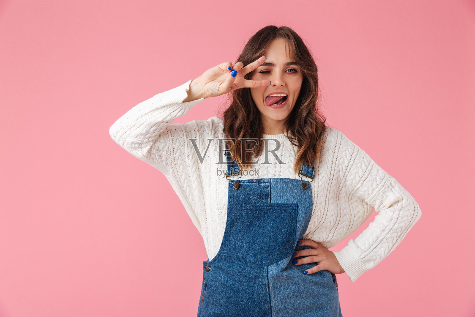 快乐的女人在休闲服装摆姿势手臂在臀部照片摄影图片