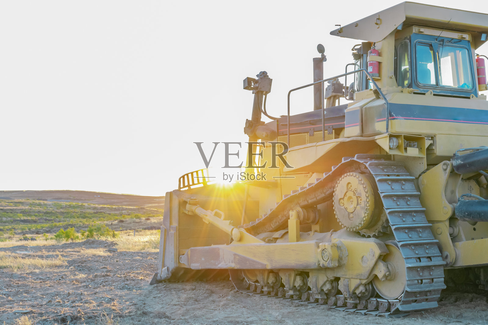 重型机械。大型拖拉机、挖掘机、推土机在一个建筑工地上，夕阳在后面照片摄影图片