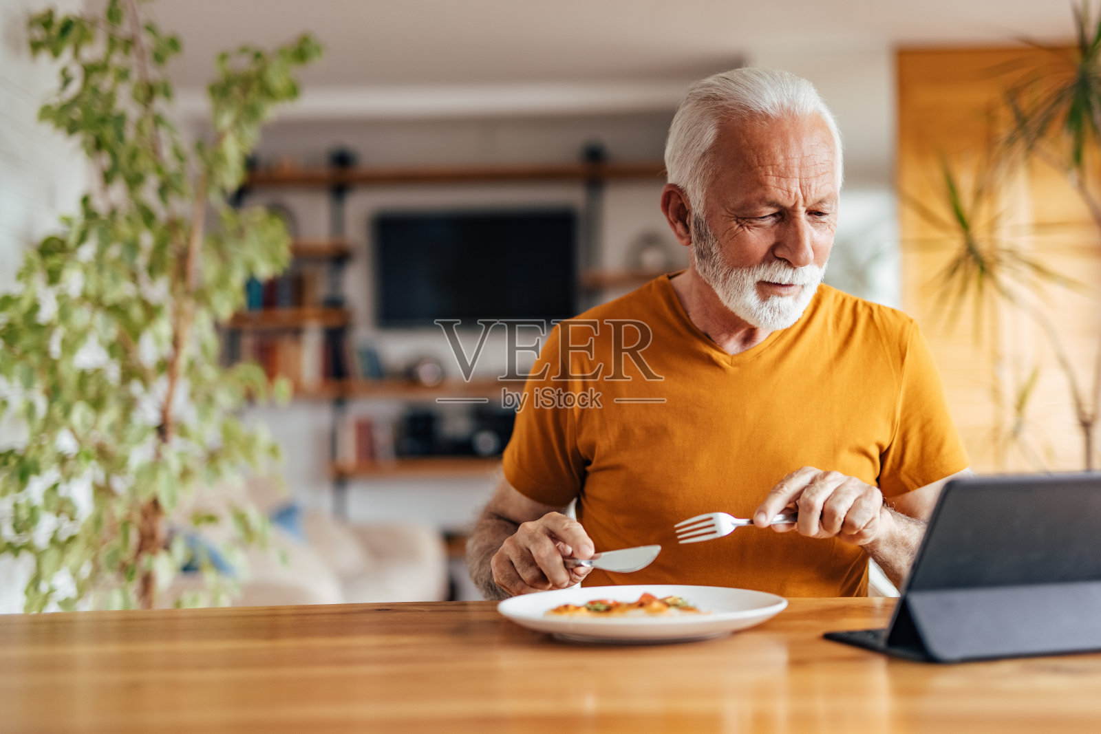 成熟的男人，一边看电影一边吃东西。照片摄影图片