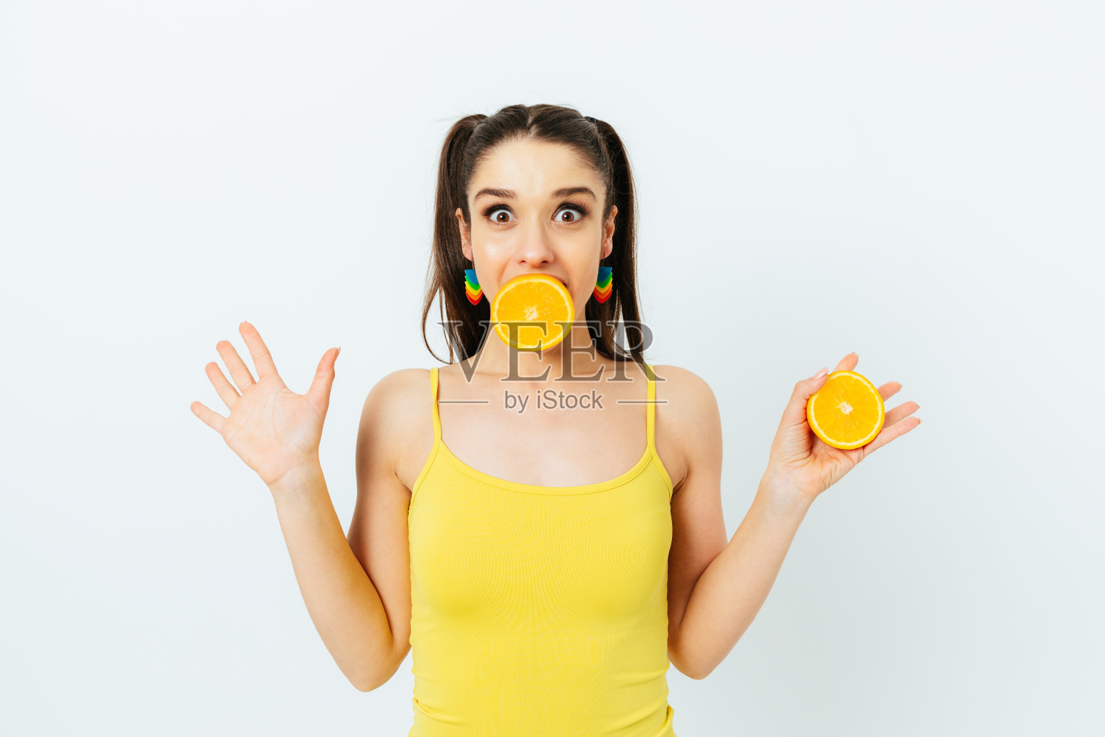 欢快活泼的年轻女子，手里拿着半个橘子照片摄影图片
