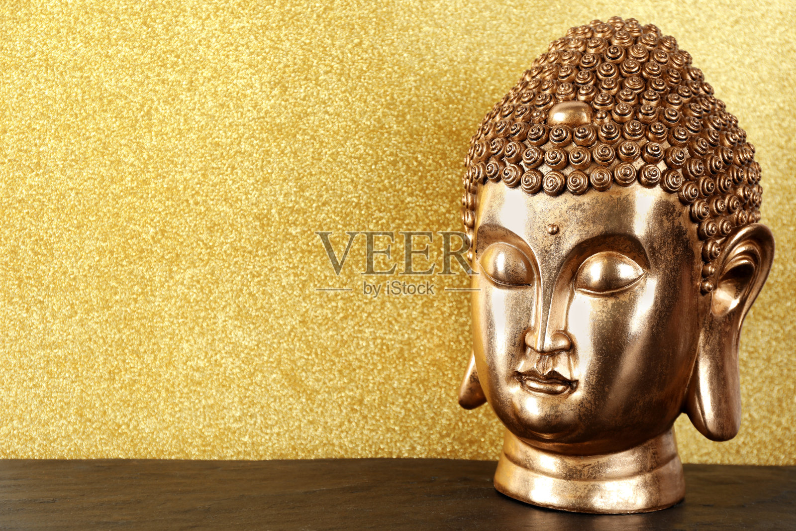 桌上的佛像以金色为背景。空间的文本照片摄影图片