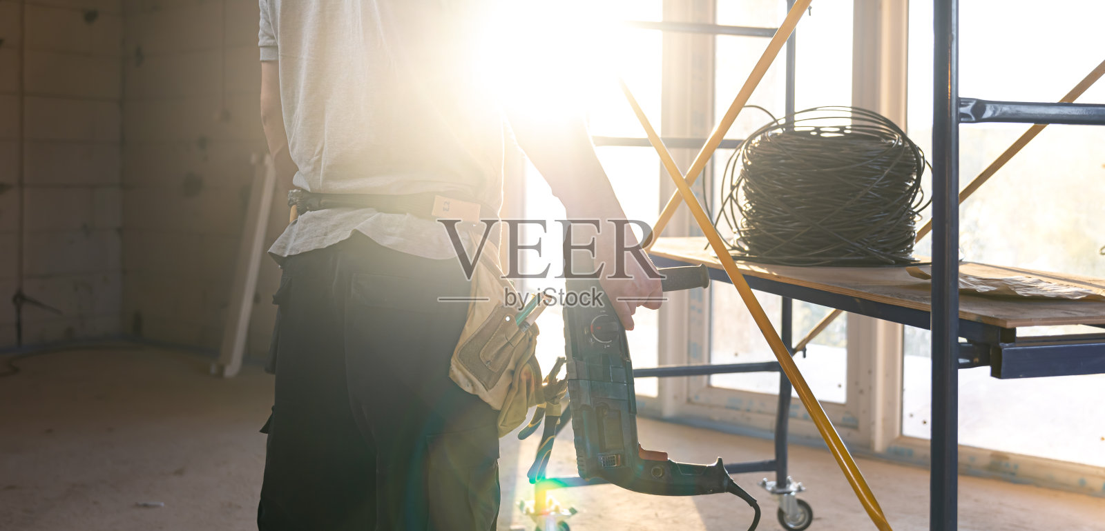 建筑工地上的工人手里拿着工具。照片摄影图片