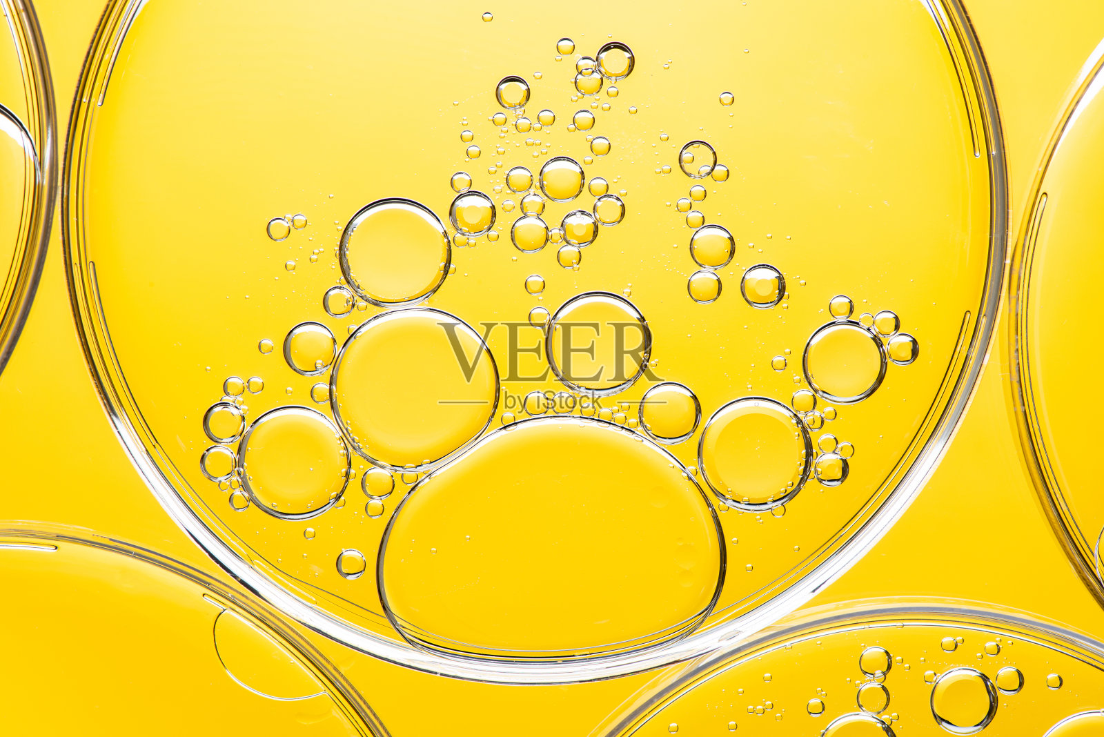 美丽的微距照片的水滴在油与黄色的背景。抽象艺术照片摄影图片