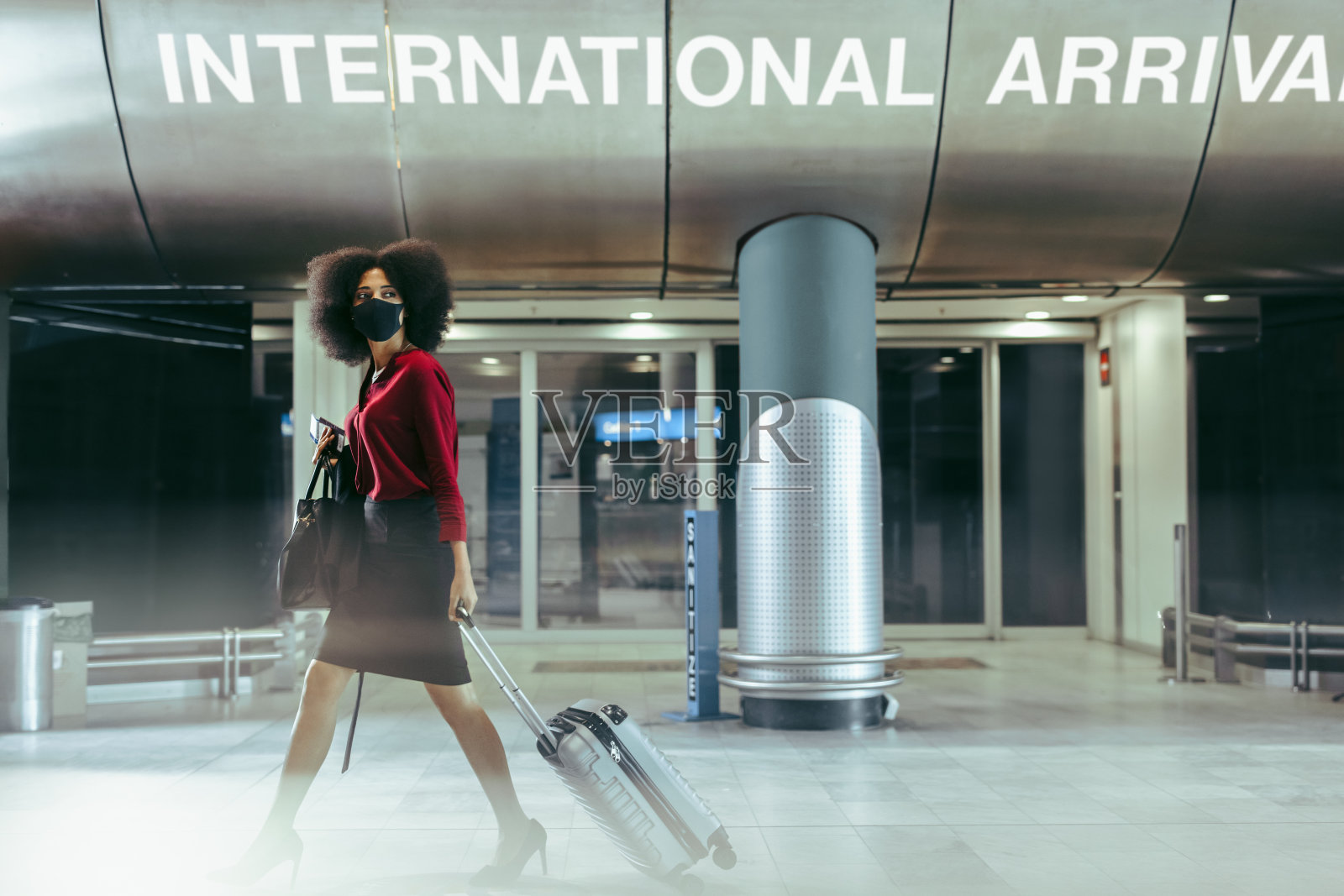 戴着口罩的女商人走过机场航站楼照片摄影图片