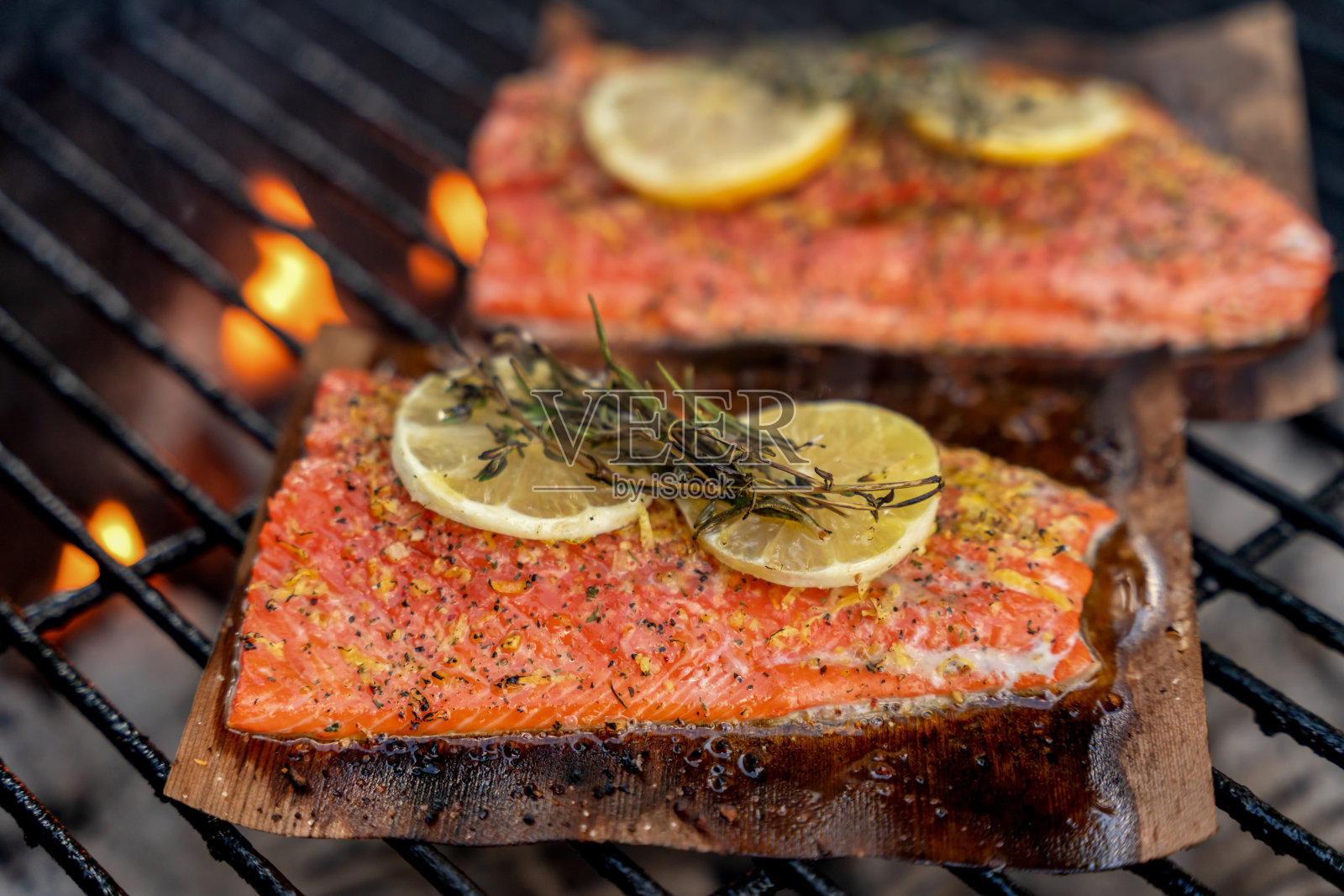 野生捕获的红鲑鱼片在热炭烧烤与火焰，近距离照片摄影图片