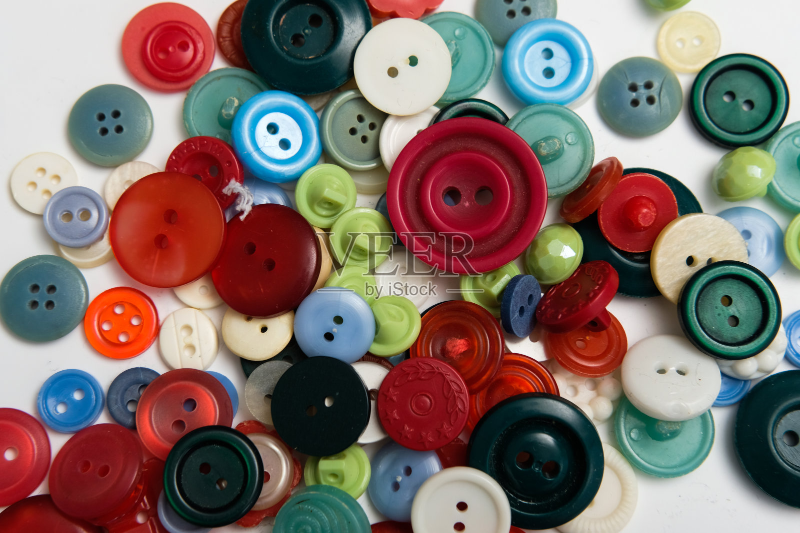 背景上不同颜色的旧塑料按钮。照片摄影图片