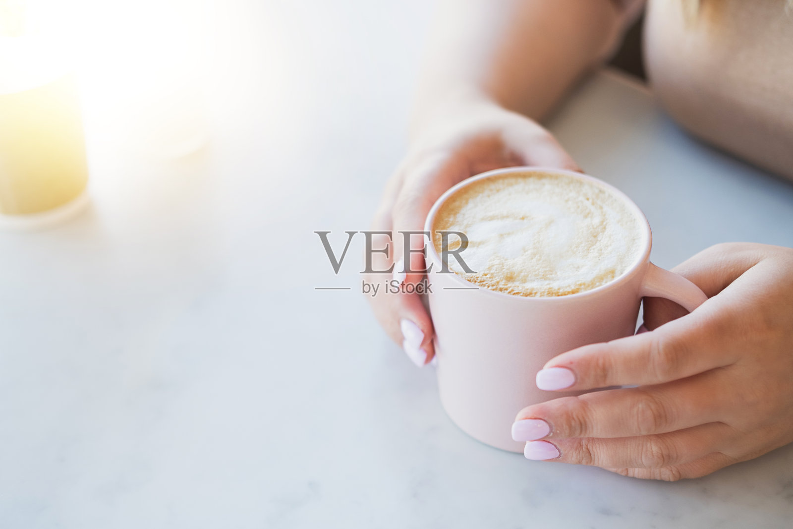 女人的手和一杯热卡布奇诺在桌子上照片摄影图片