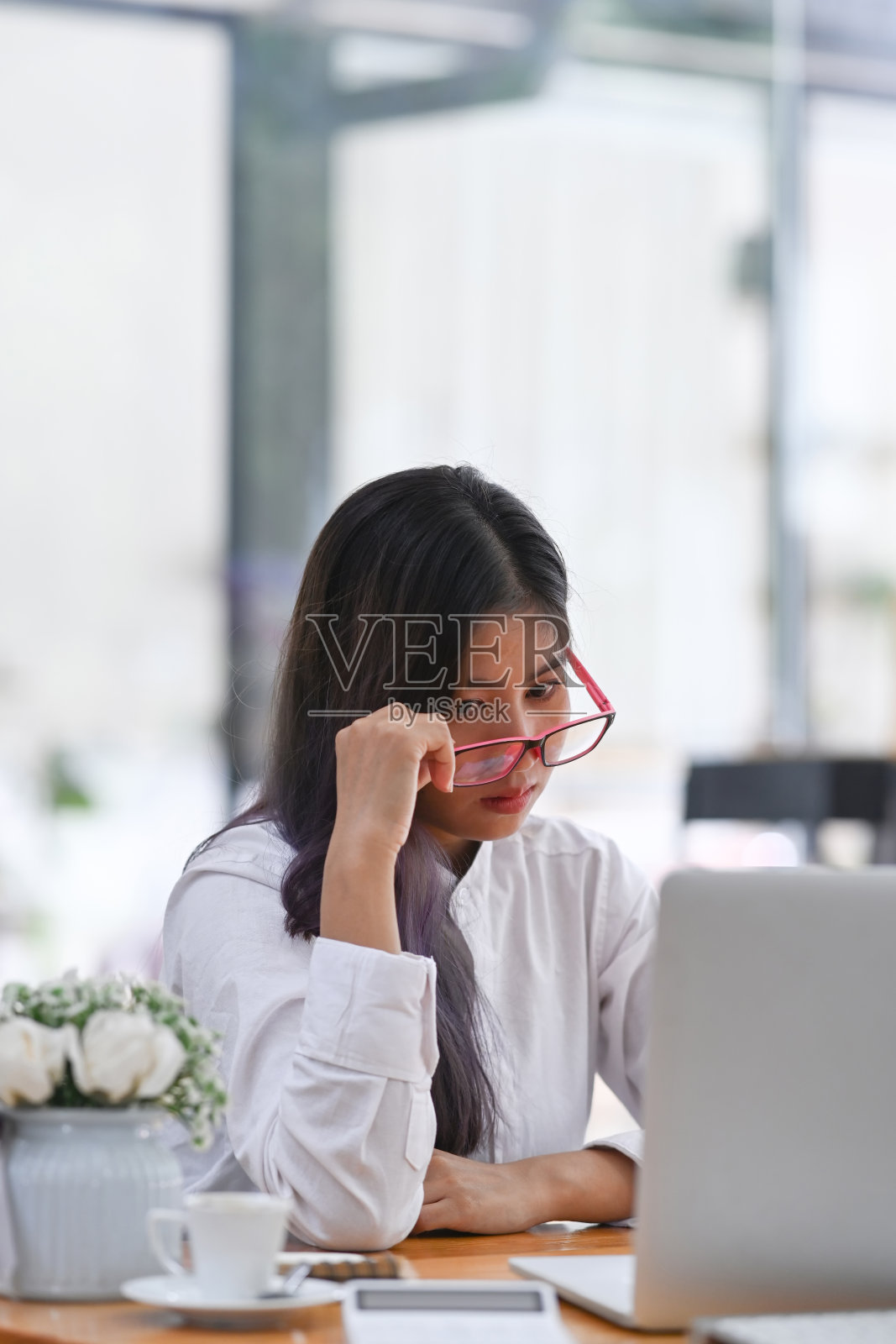 郁闷无聊的女商人坐在办公桌前。照片摄影图片