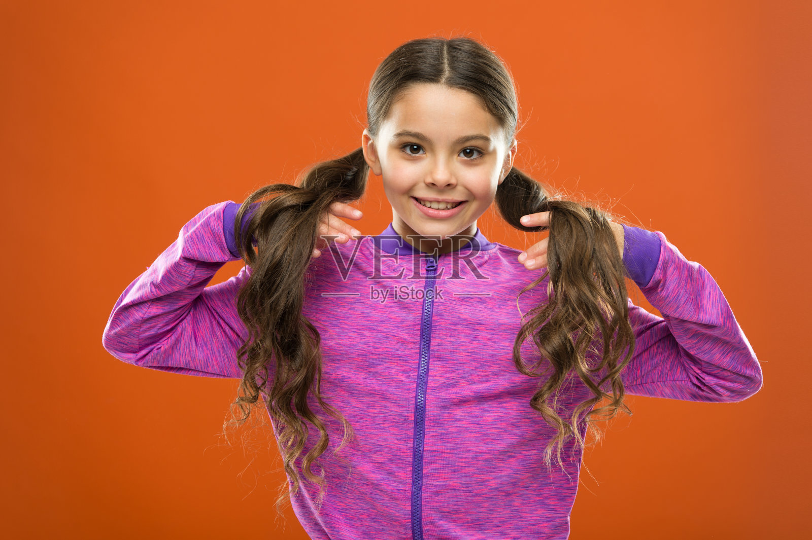 童年的幸福。家庭。儿童时尚和运动装。长头发的快乐小女孩。儿童的一天。快乐小孩的肖像。小女孩的孩子。理发师给孩子们。小宝贝照片摄影图片