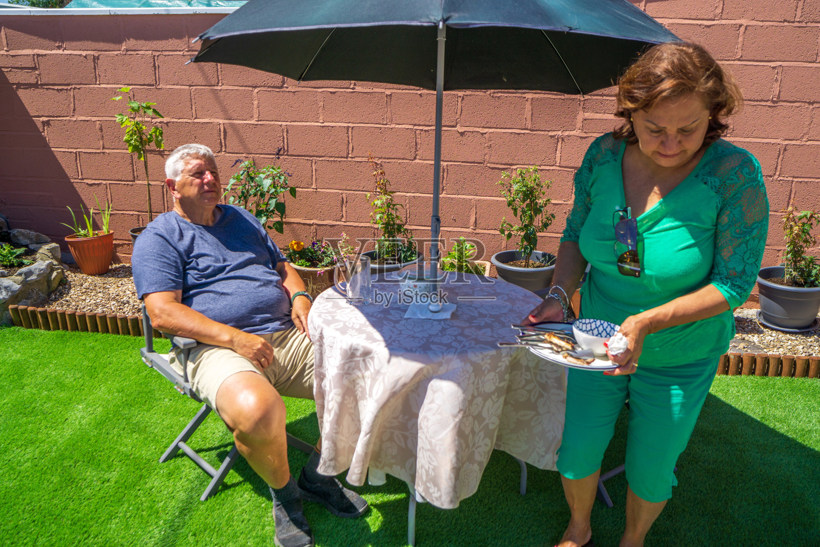 老夫妇在草坪上吃午饭照片摄影图片