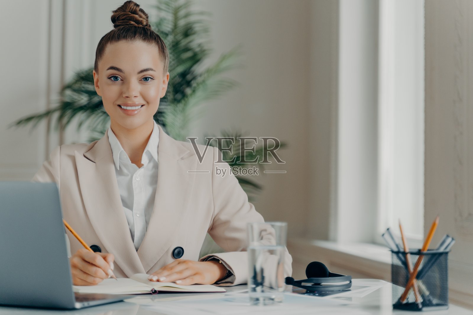 年轻成功的女性自由职业者在记事本上记录信息照片摄影图片