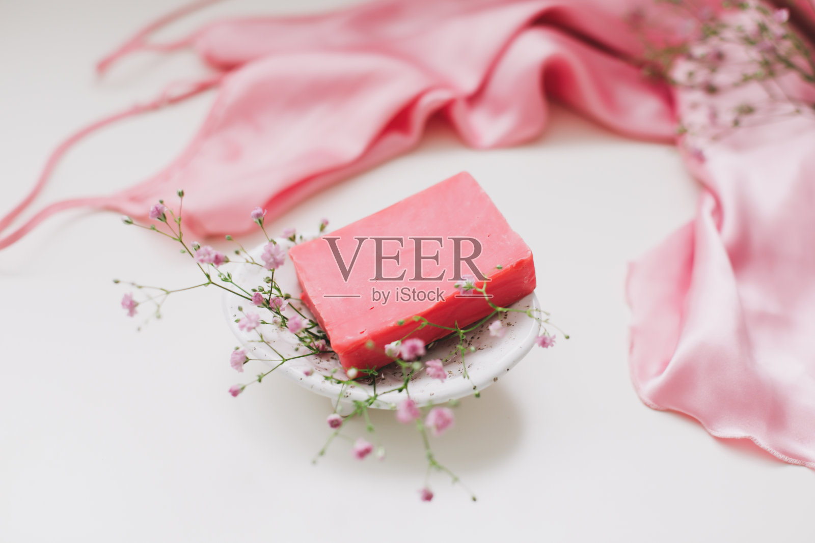 手工制作的天然肥皂与陶瓷盘子，粉色银色的连衣裙。肥皂酒吧。温泉,皮肤护理。天然有机水疗美容产品照片摄影图片