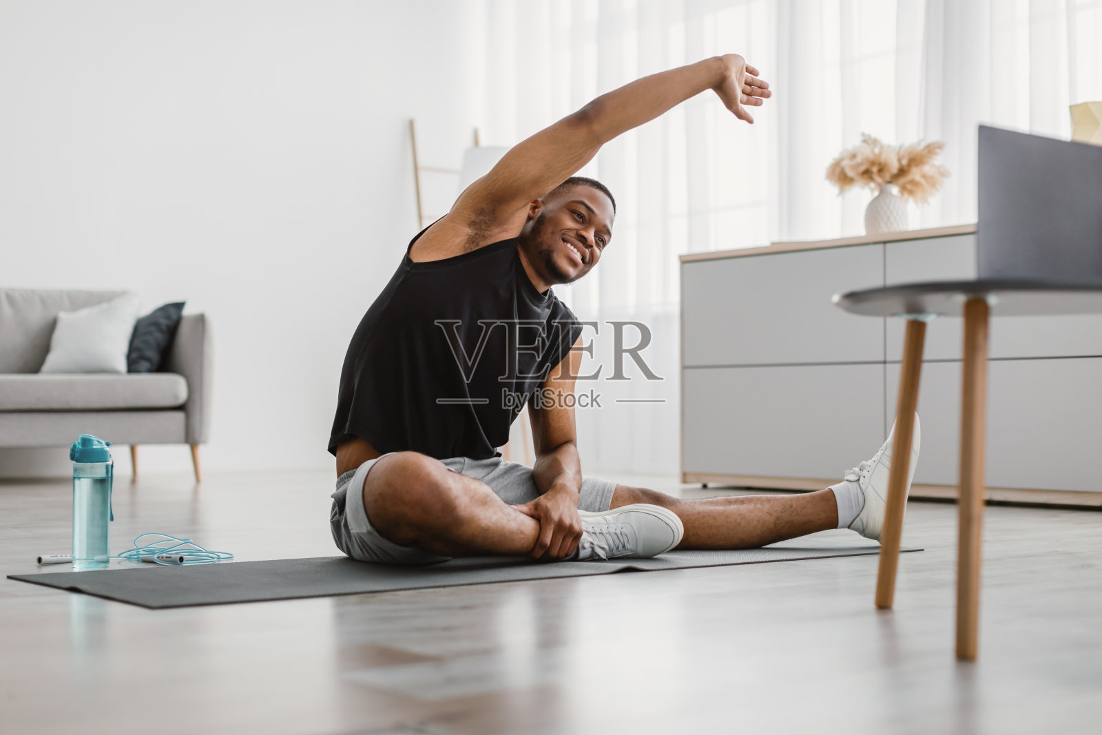愉快的黑人在家里做侧弯伸展运动照片摄影图片