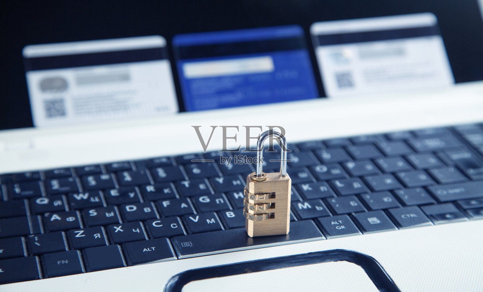 电脑键盘上的挂锁和信用卡。信用卡的安全照片摄影图片