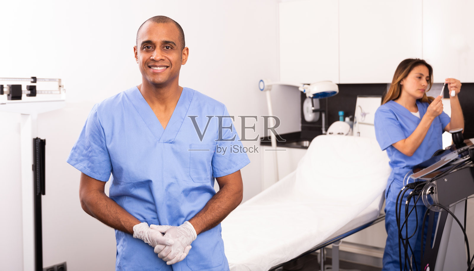 微笑的专业男化妆师在诊所会见病人照片摄影图片