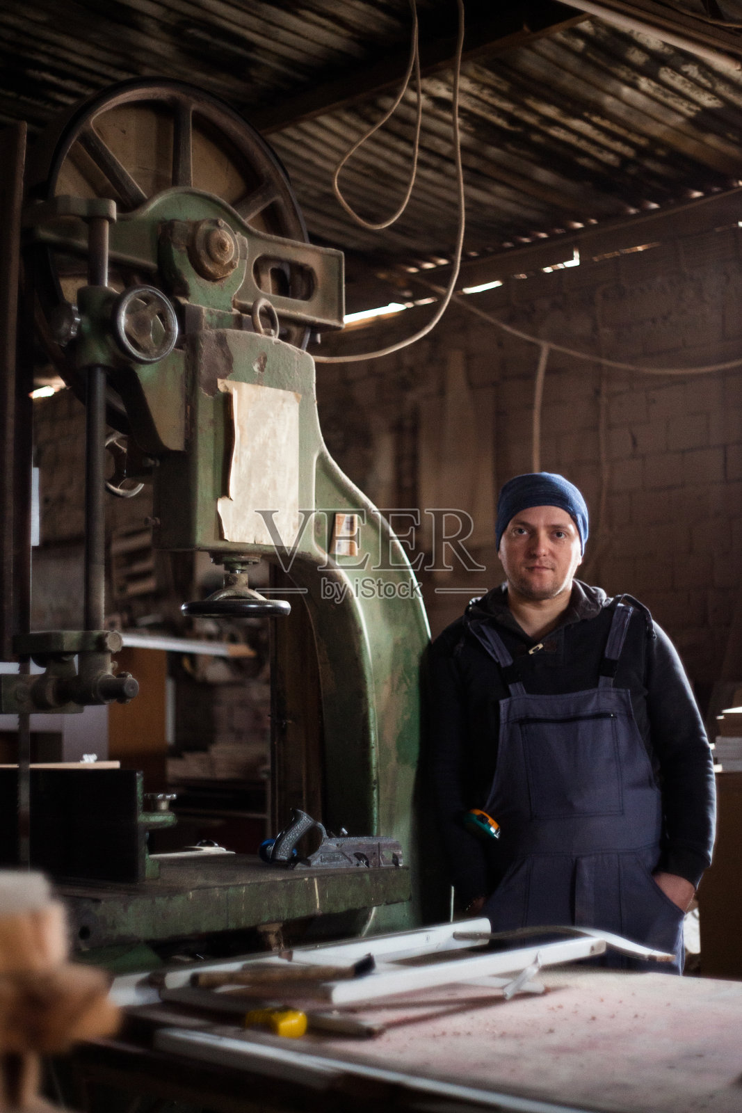 年轻的木匠在他的工作车间里照片摄影图片