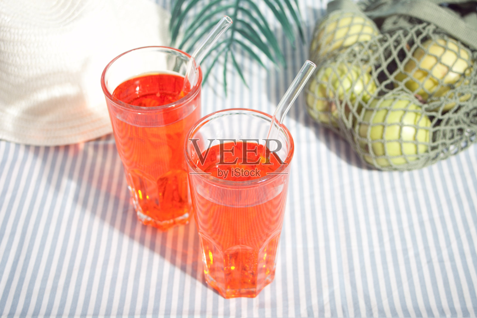 夏日清爽的鸡尾酒和绿苹果装在一个网袋里野餐照片摄影图片