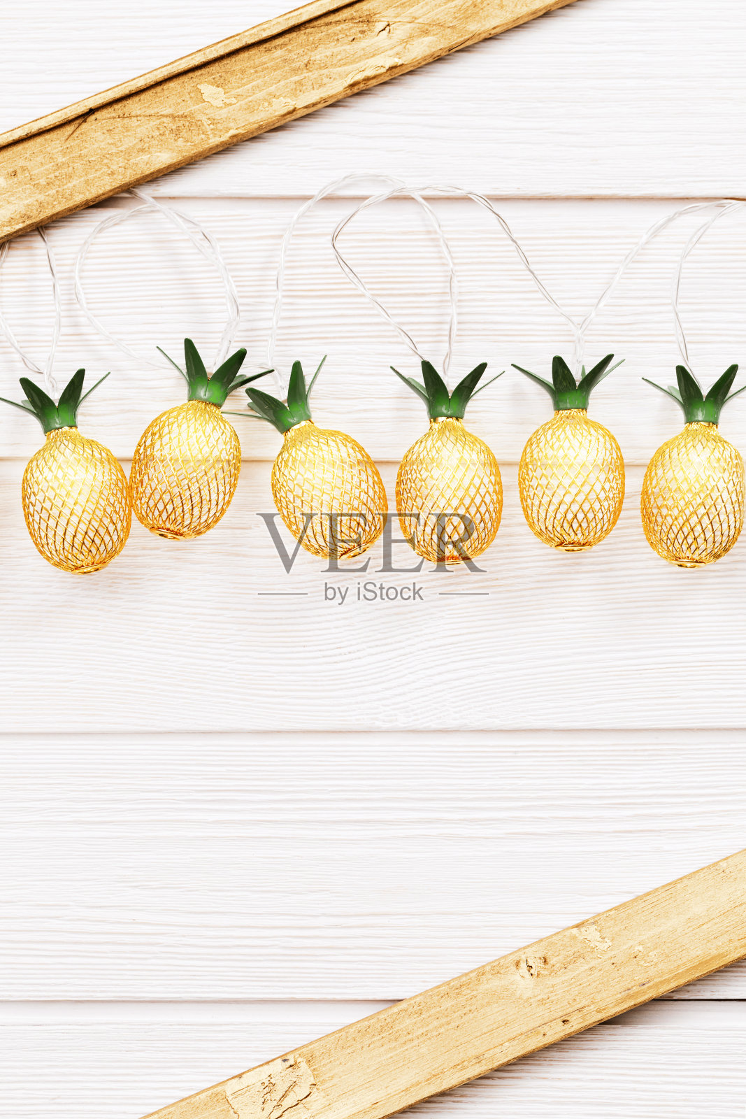 假日家庭装饰用菠萝灯金色的白色木材。温暖的灯光营造舒适的氛围。照片摄影图片