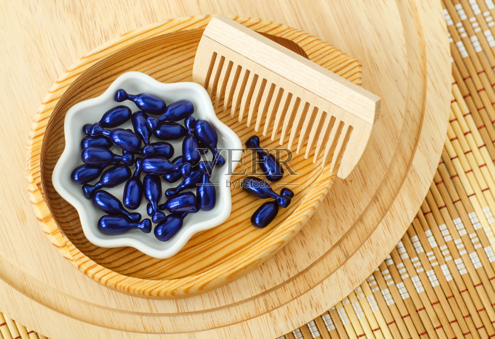 小木碗，装有化妆油胶囊(眼部或发膜，面部精华液)和木质发刷。天然水疗、护肤、护发及美容配方。俯视图，复制空间。照片摄影图片