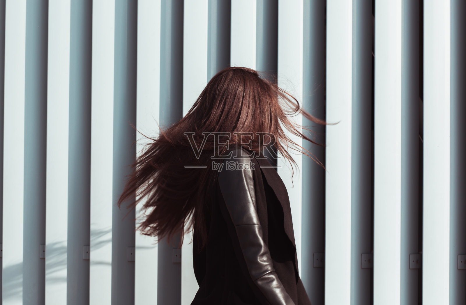 生活方式肖像的可爱的年轻模特的头发在风中飘扬，穿着时髦的服装照片摄影图片