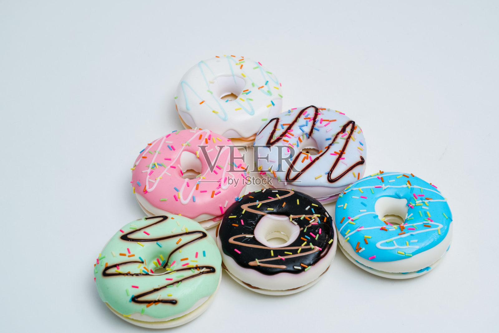 明亮多彩的甜甜圈放在纯色的背景上照片摄影图片