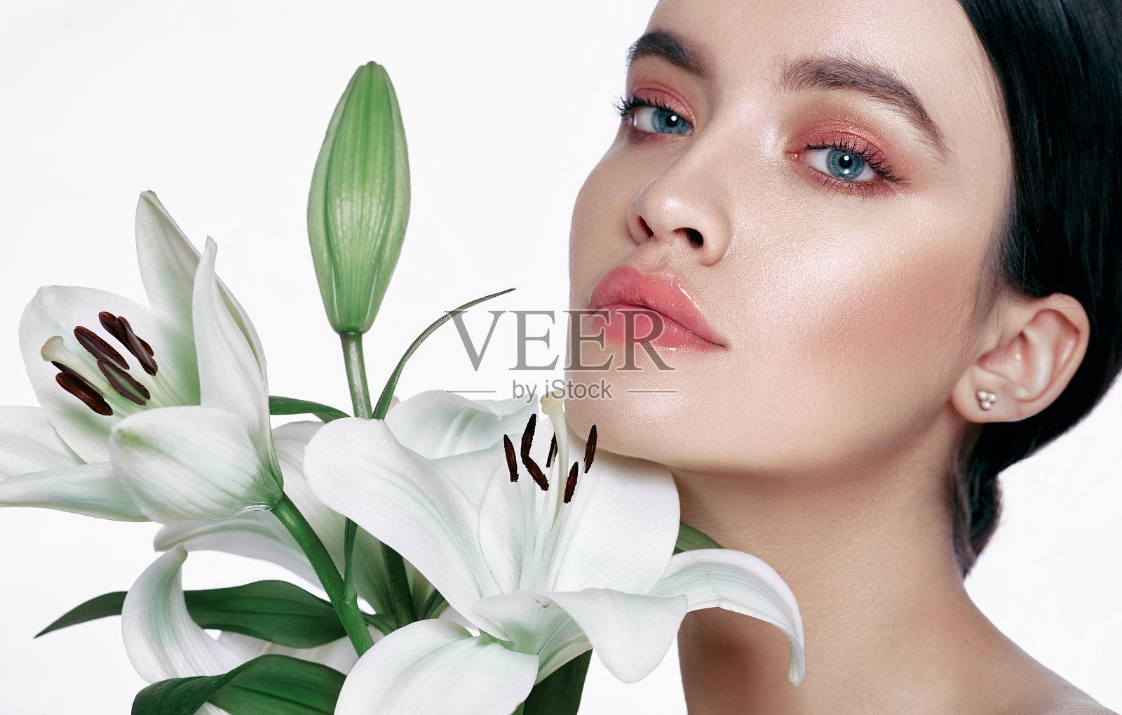 完美女性面容，护肤。美丽的女人有干净，新鲜，健康的皮肤，孤立在一个白色的背景与花照片摄影图片
