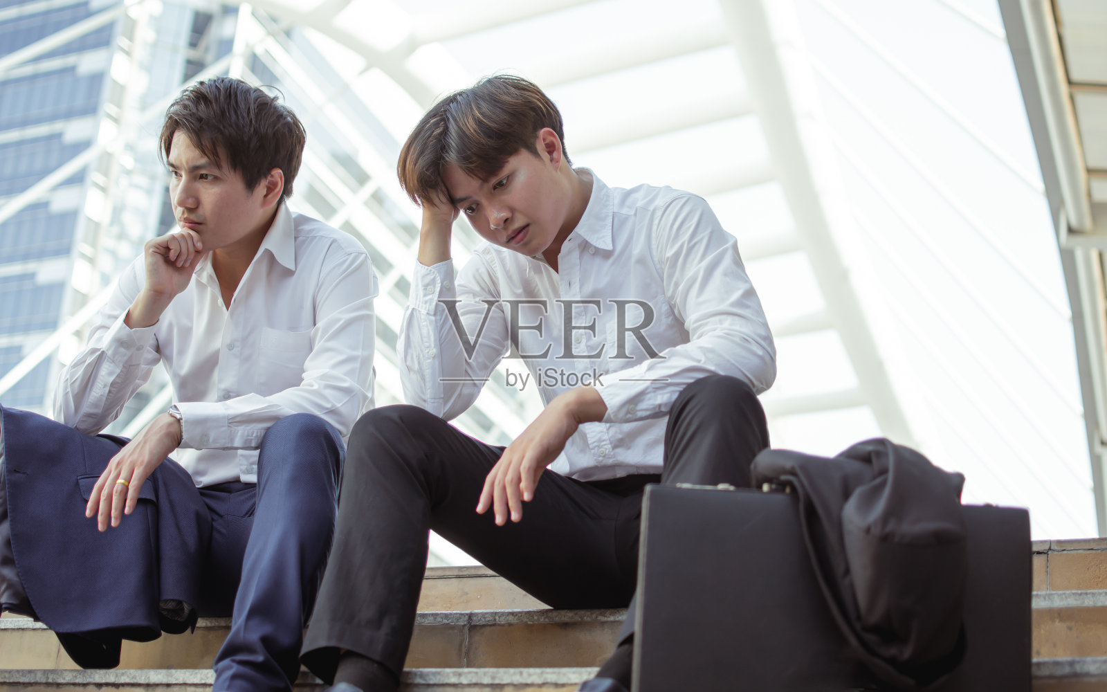 两个失业工人坐在路边，很伤心照片摄影图片